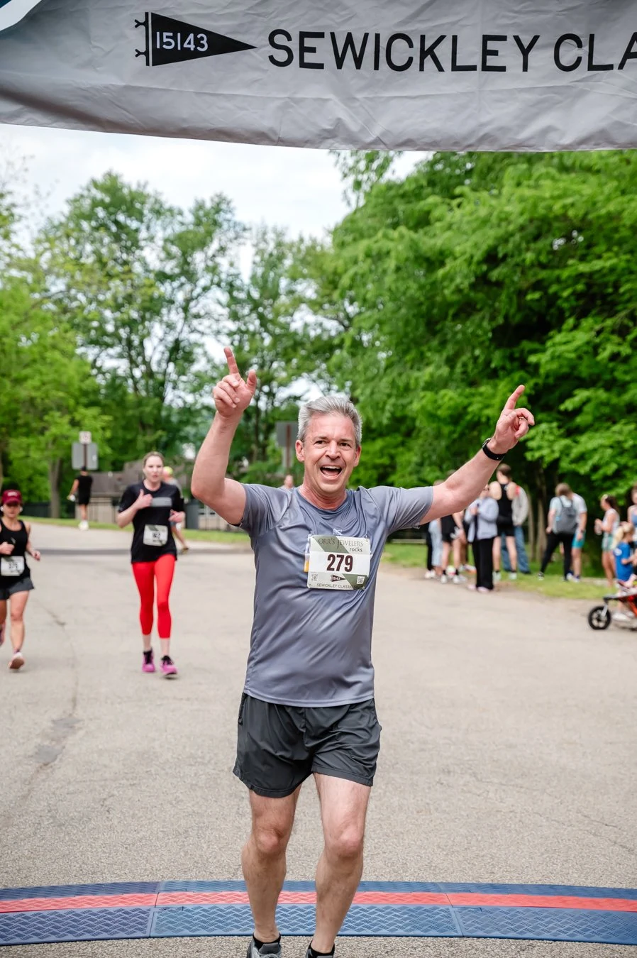 A smiling runner finishing the 2026 Sewickley Classic